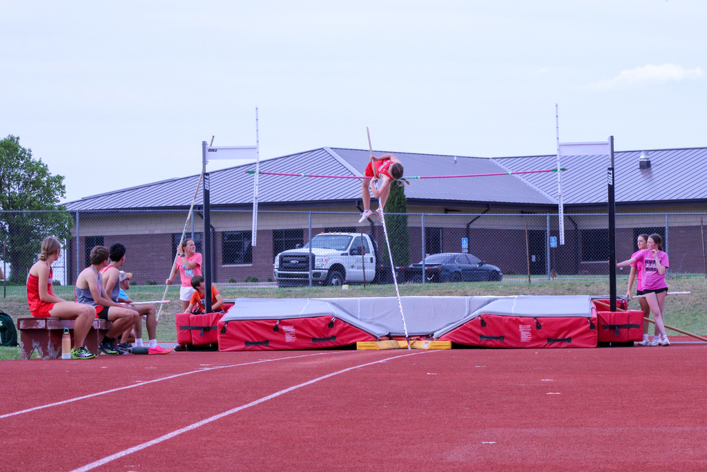 student mid air pole vaulting