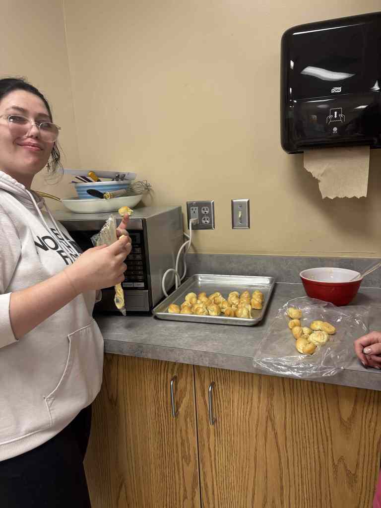 student smiling and showing off hard work of crombuche