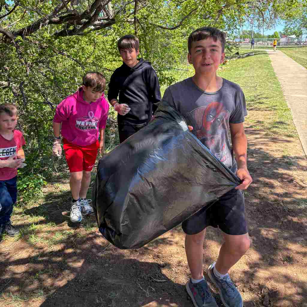 group of students cleaning up school grounds