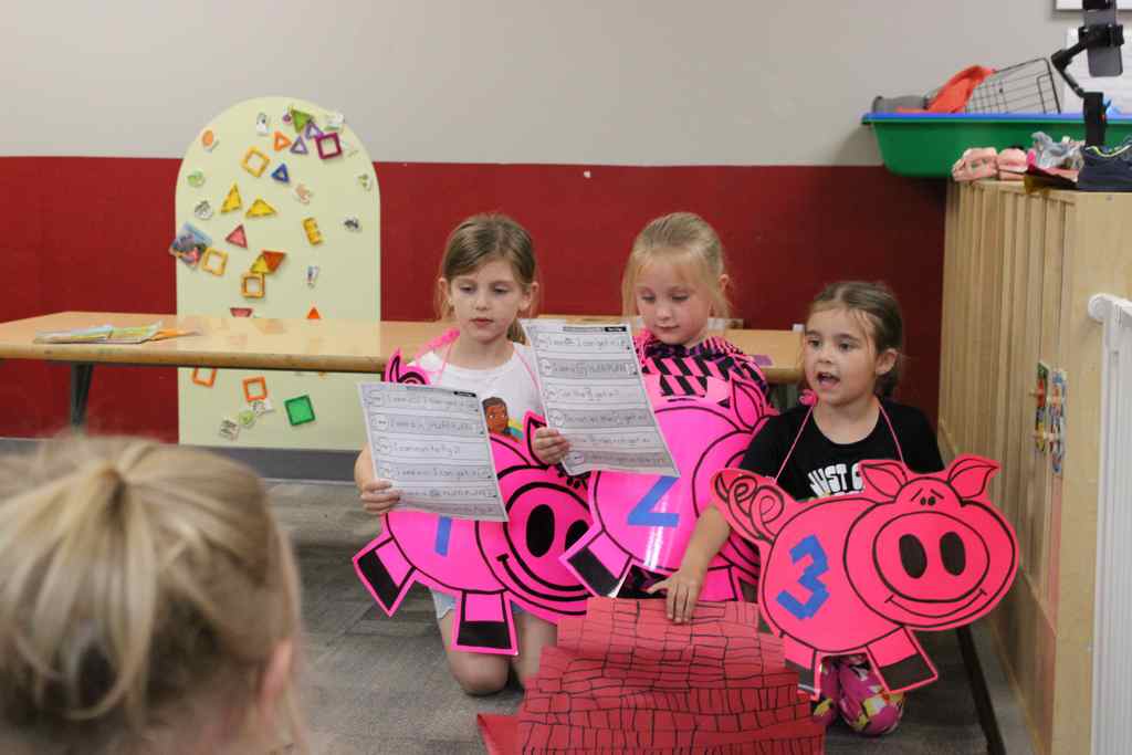 three students playing the three litle pigs