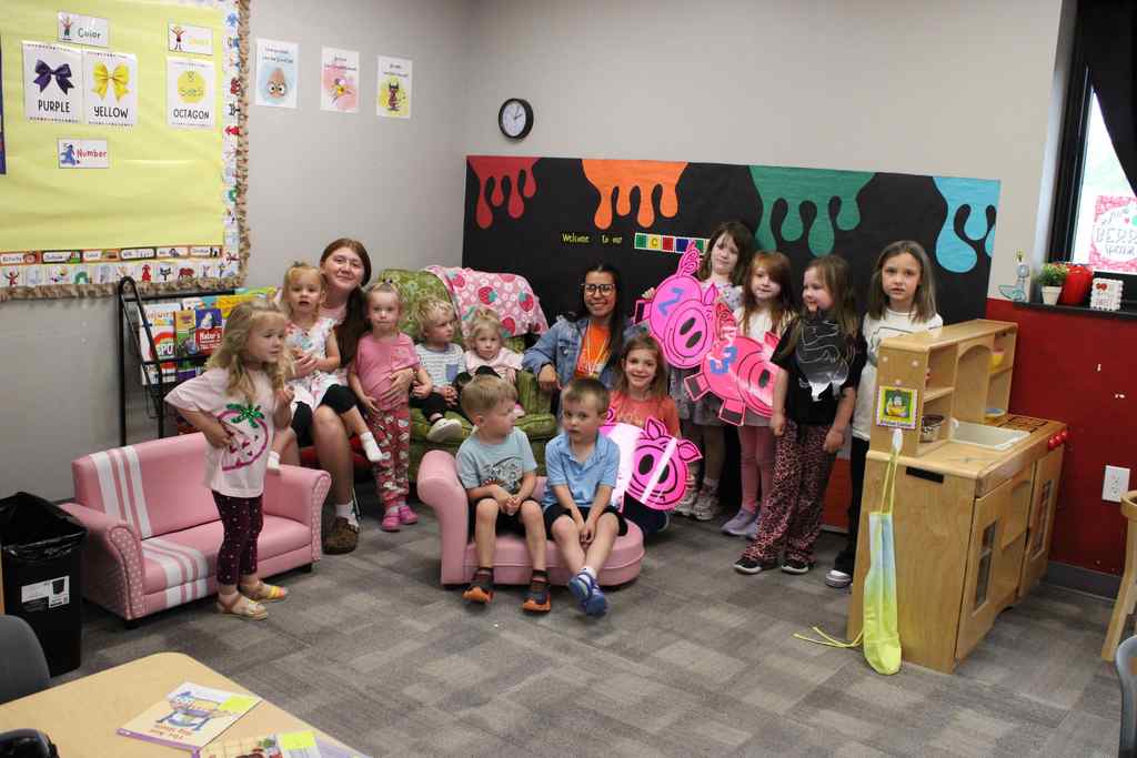 Group of students ranging in age from toddler to kindergarten posing for the camera
