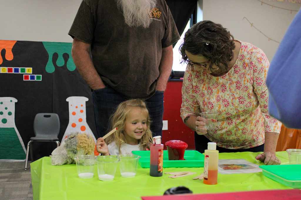 A close-up of students working with colorful materials during a classroom art or science lesson.