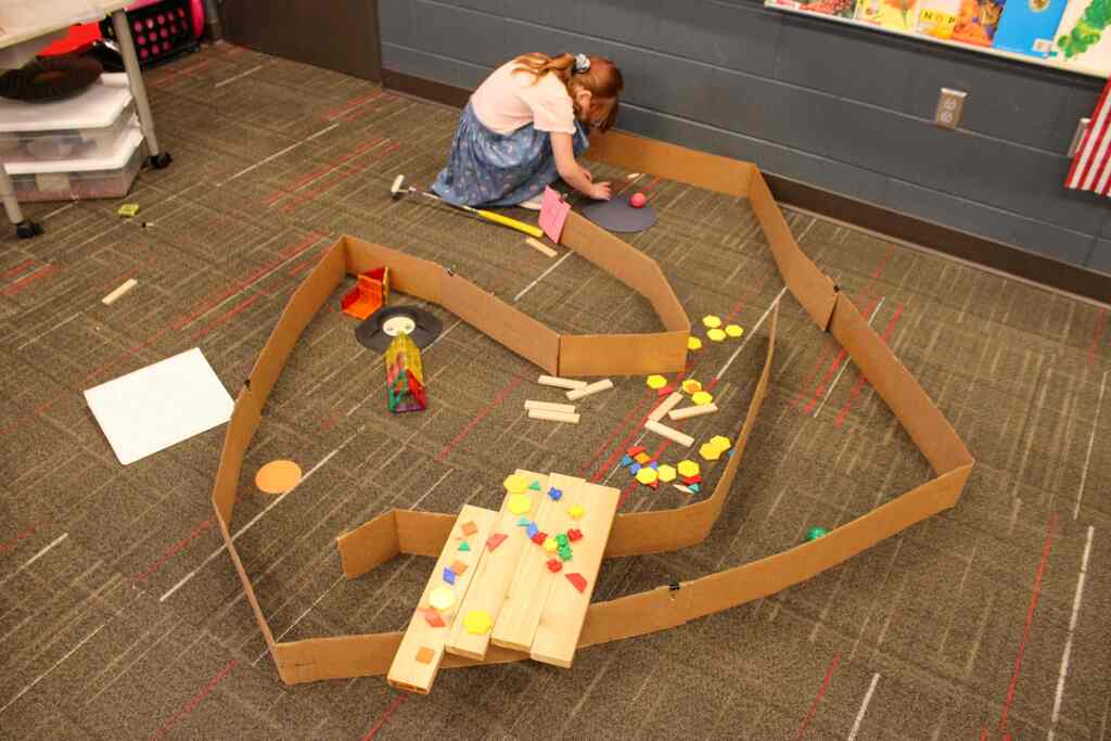 a student adjusting the layout of their mini-golf course
