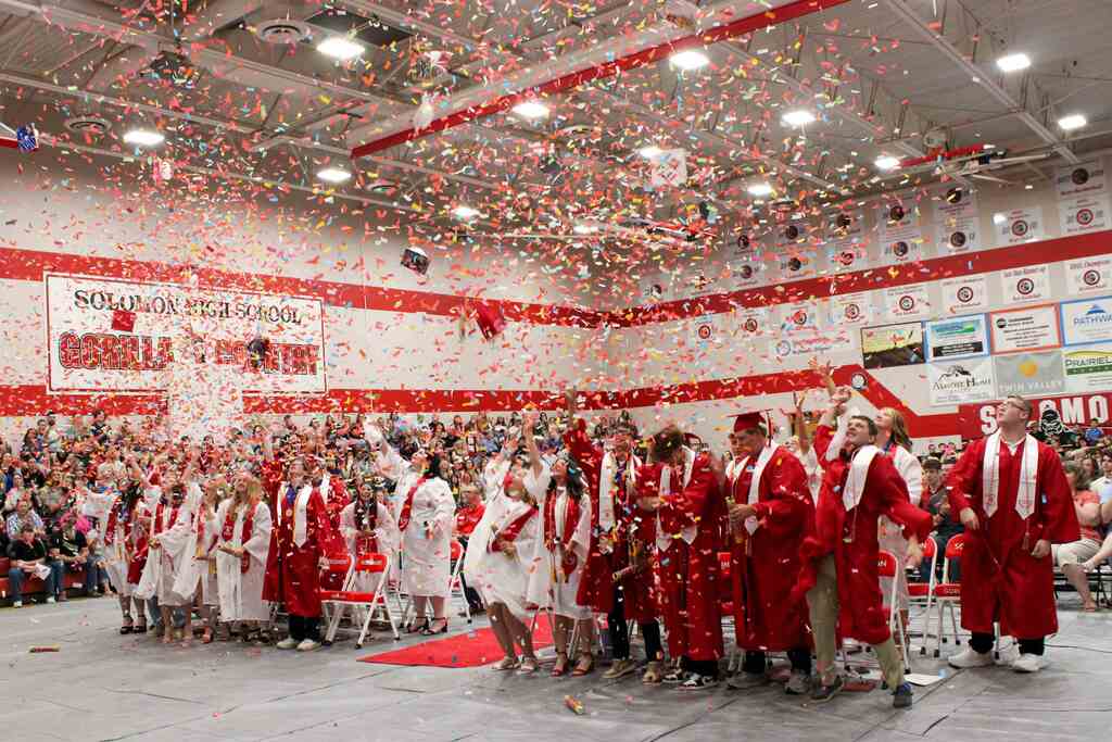 Class of 2026 throwing their caps up amisdst confetti during graduation