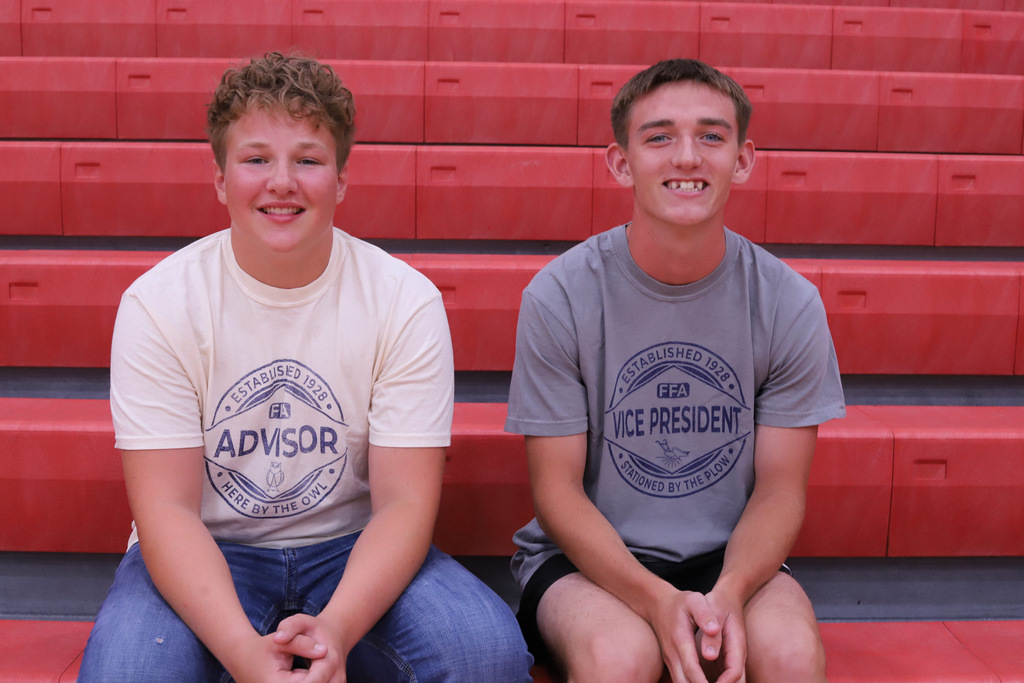 Jordan and Breken sitting on red benches 