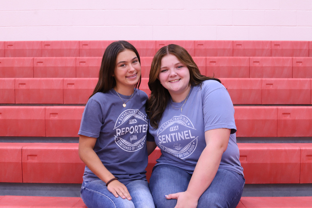 Brielle and Abbigail posing on red benches