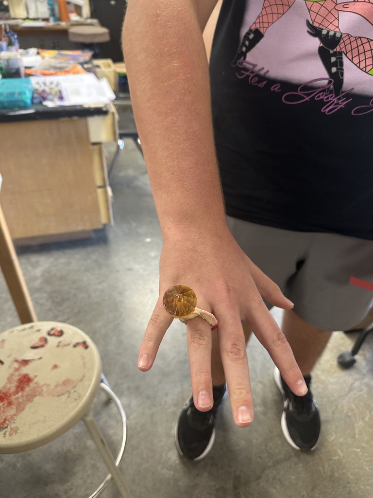 student showing off their handmade cardboard ring