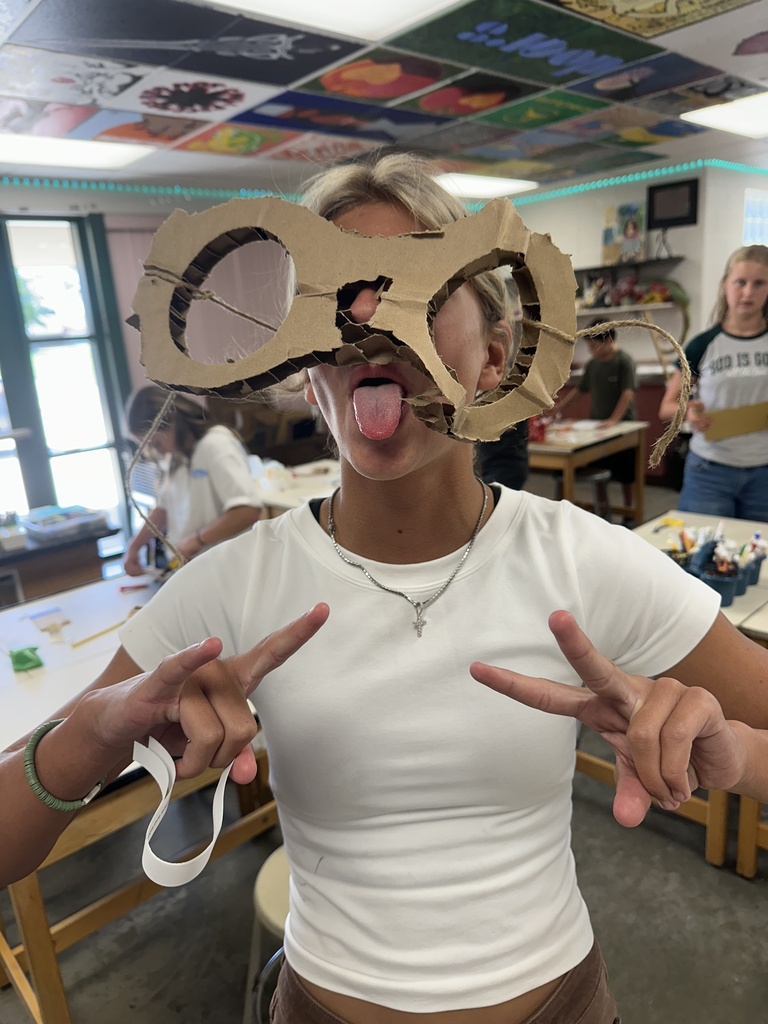 student wearing homeade cardboard glasses that are oversized
