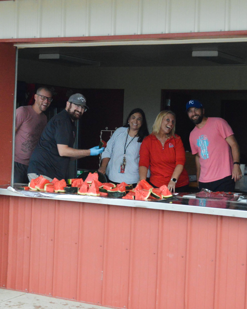 staff members helping with the watermelon feed