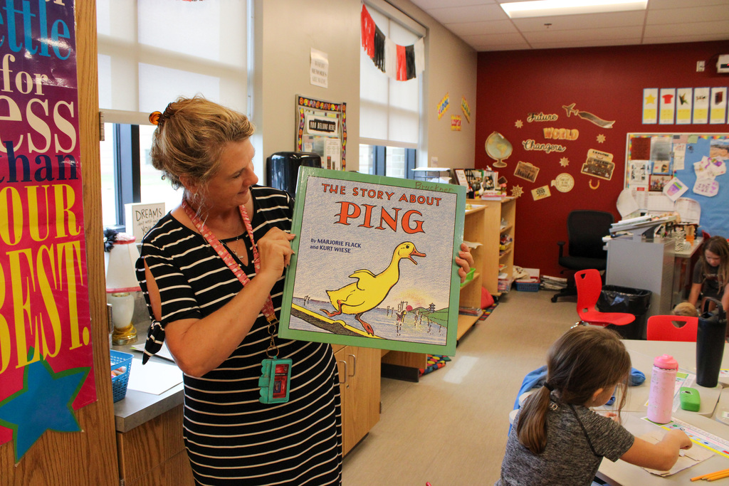 Mrs Hunsche holding up a book