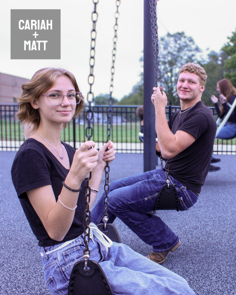 two homecoming students sitting in a swing facing opposite directions and looking at the camera