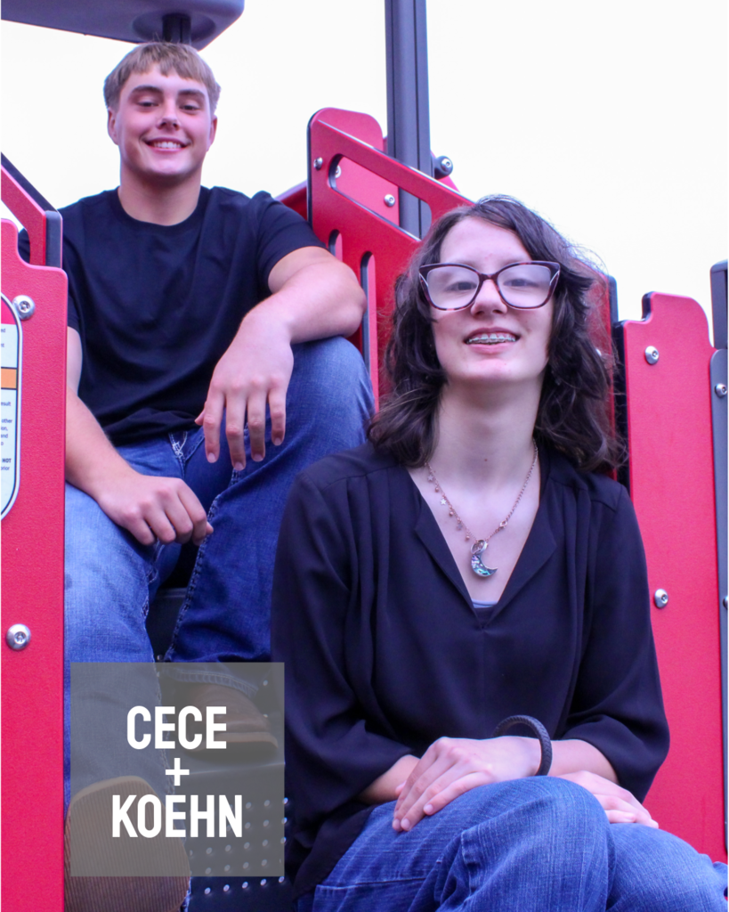 two homecoming candidates sitting on a playground set with the lens zoomed in