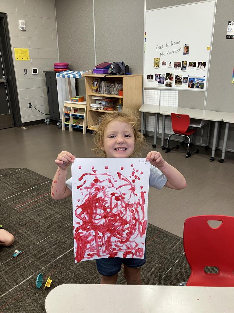 students painting with red paint on white paper
