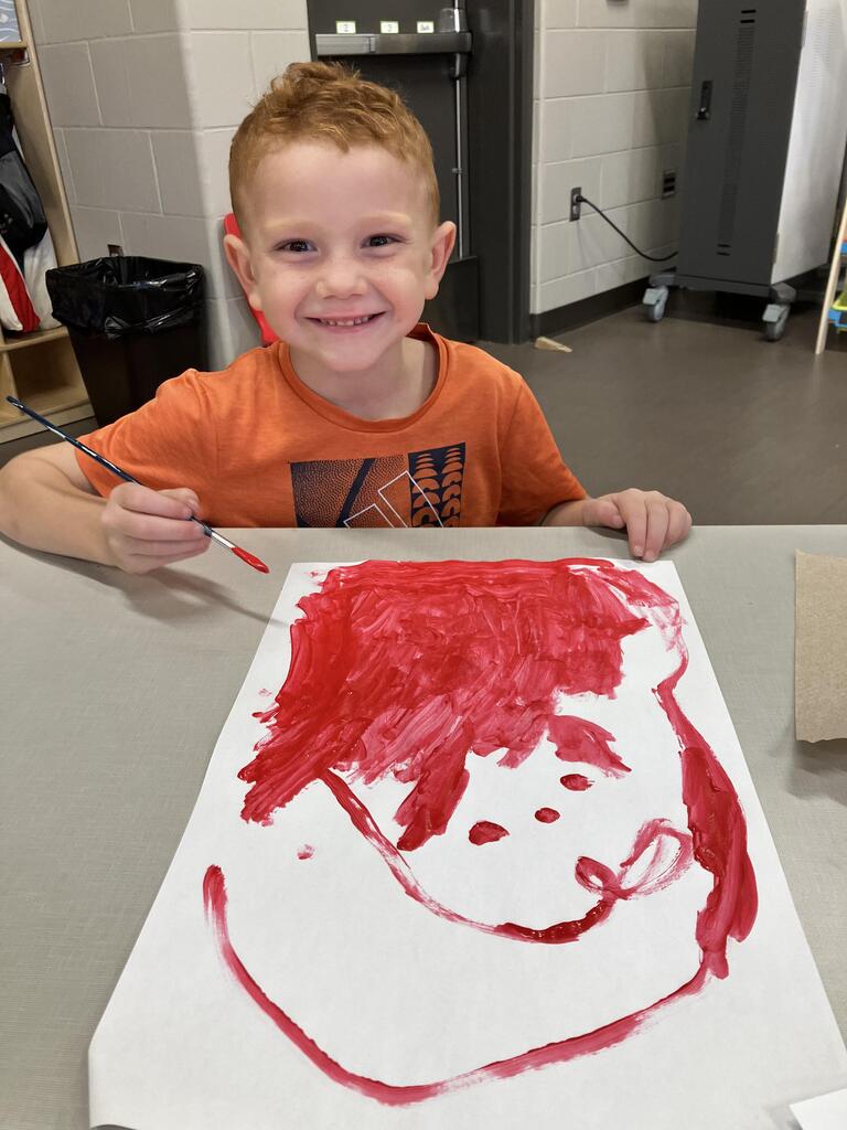 students painting with red paint on white paper