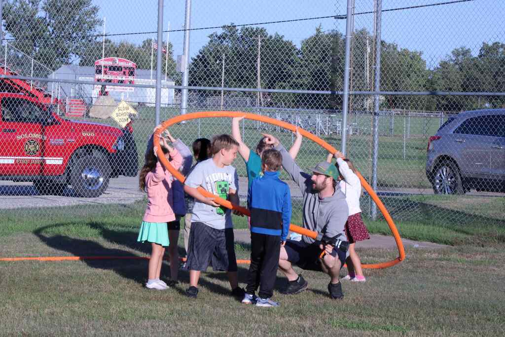 students working together to hold up the water hose