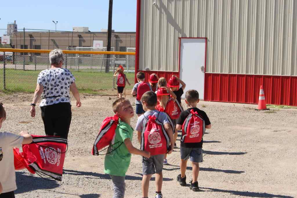 students walking away from camera wearing their fire safety bags