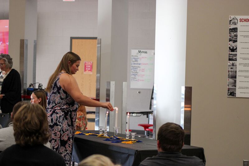 NHS member lighting the ceremonial candle
