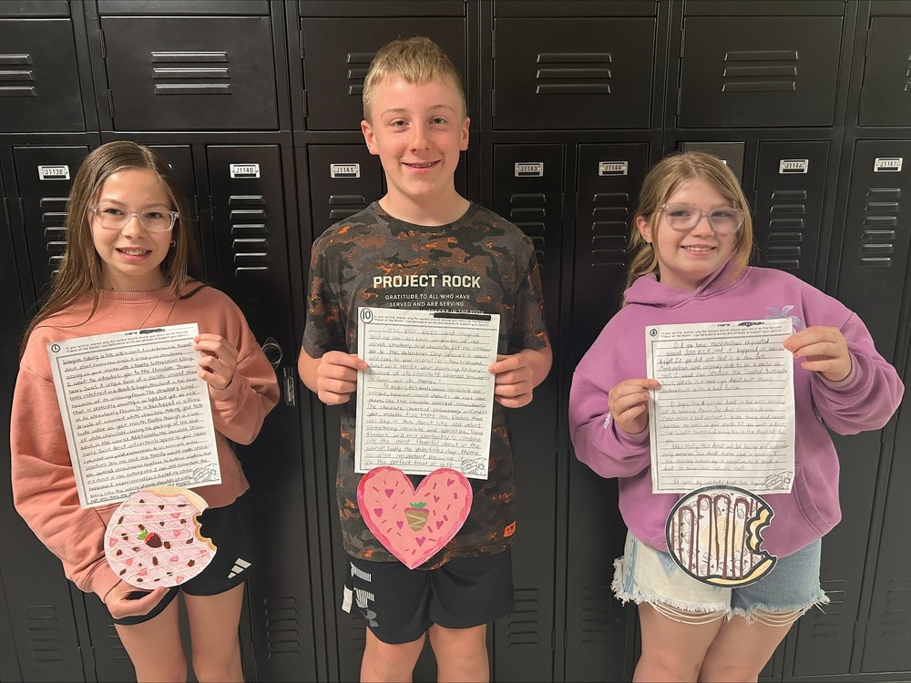 3 Students display their writing assignments. 