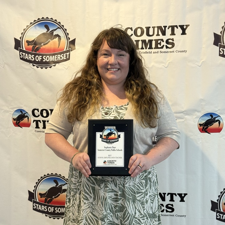 Woman holding a plaque and smiling