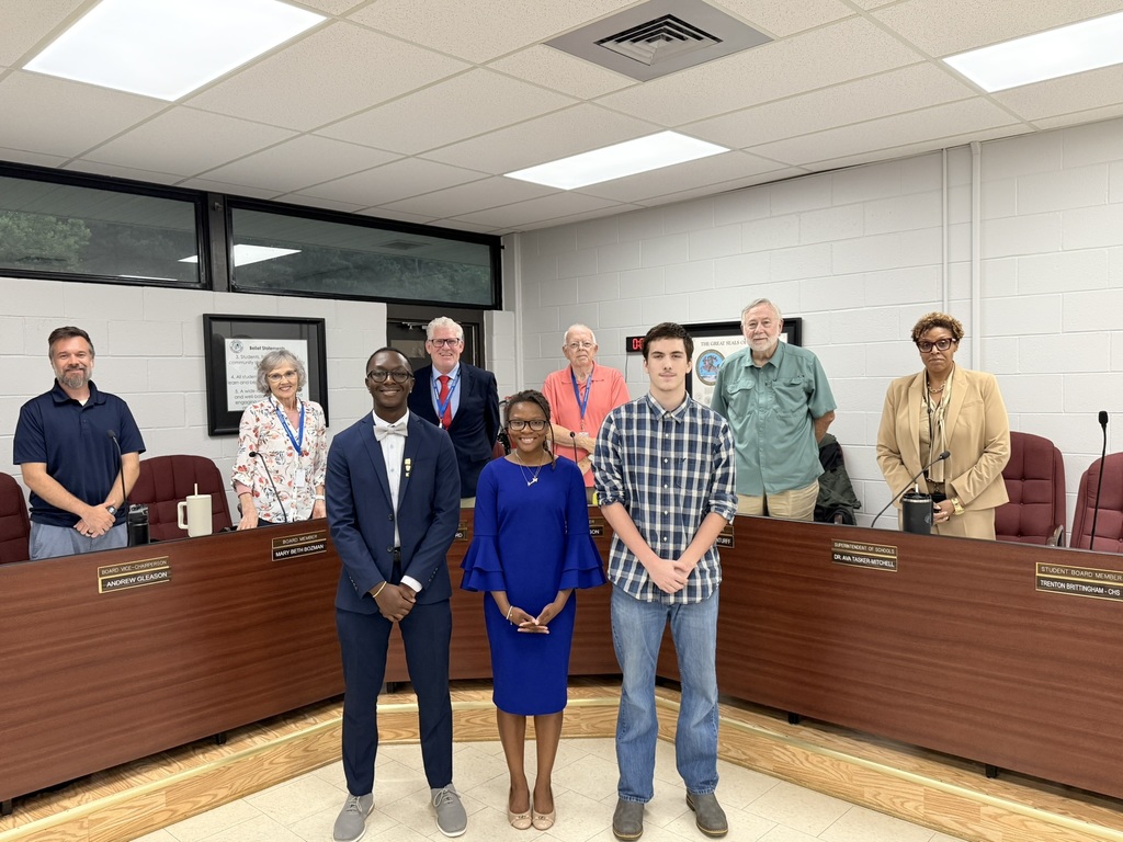 Student board reps standing in front of board of education members in the board room