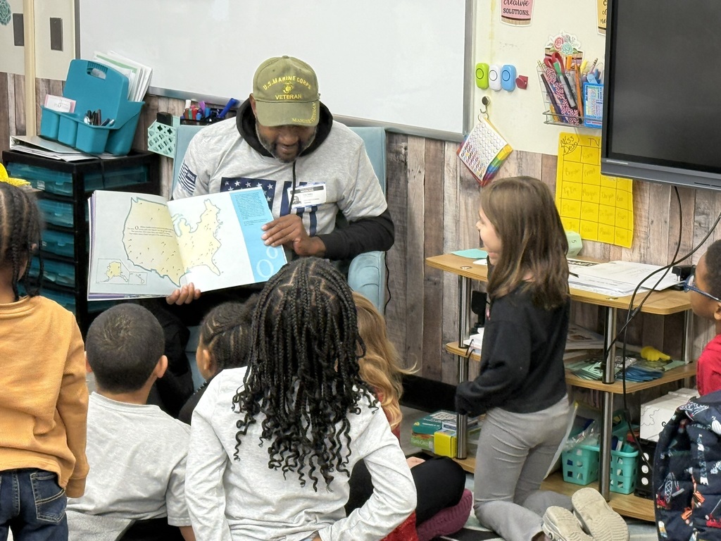 a veteran reading to children in a classroom