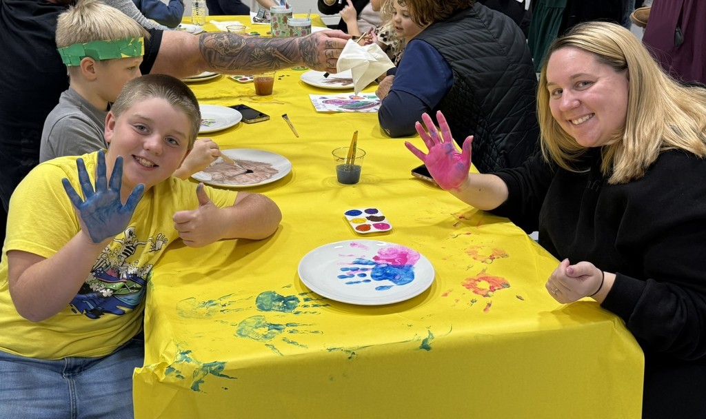 pictures of families enjoying a dinner plate painting craft at DIS' American Education Week Event