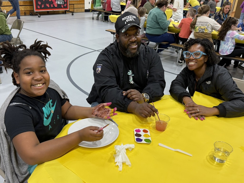 pictures of families enjoying a dinner plate painting craft at DIS' American Education Week Event
