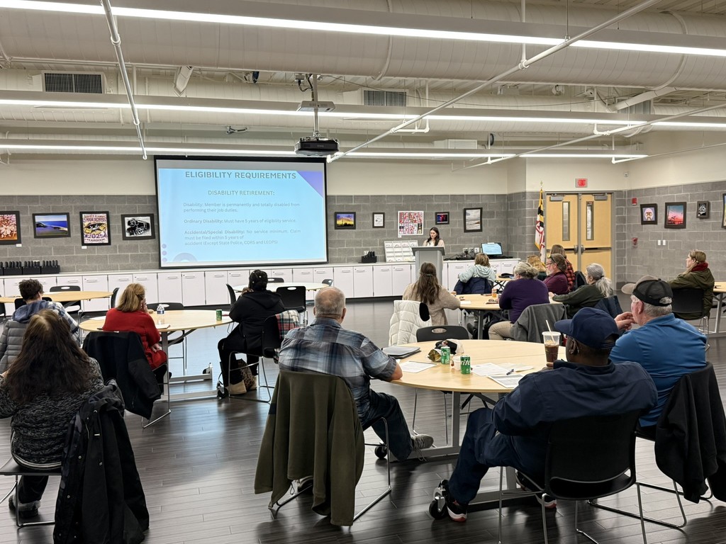 woman giving a presentation about retirement in a room with an audience