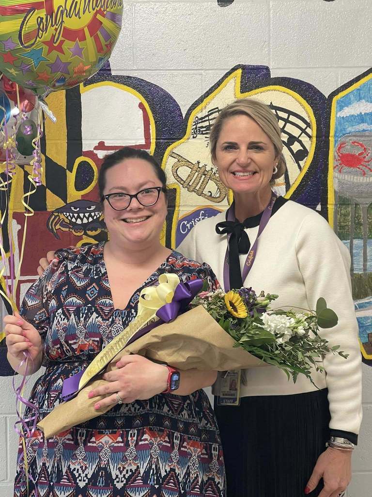 Teacher of the year with her principal smiling with flowers and balloons