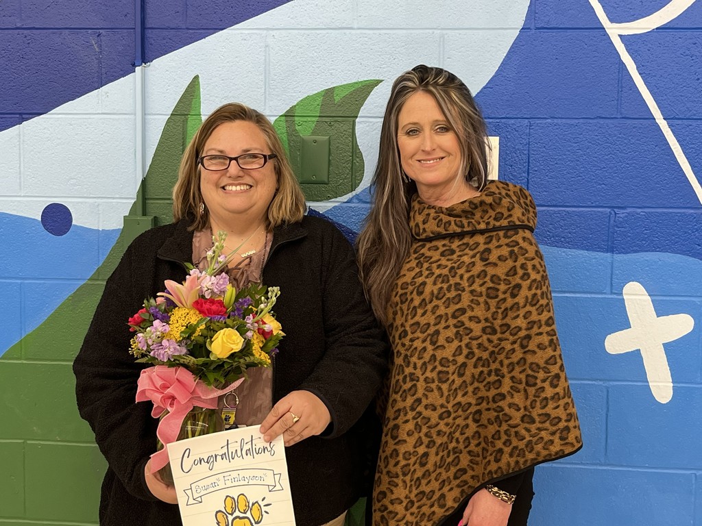 teacher receiving an award smiling next to her principal