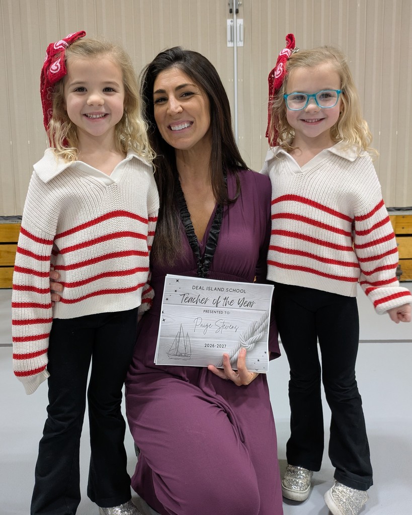 teacher of the year holding certificate next to two school aged children 