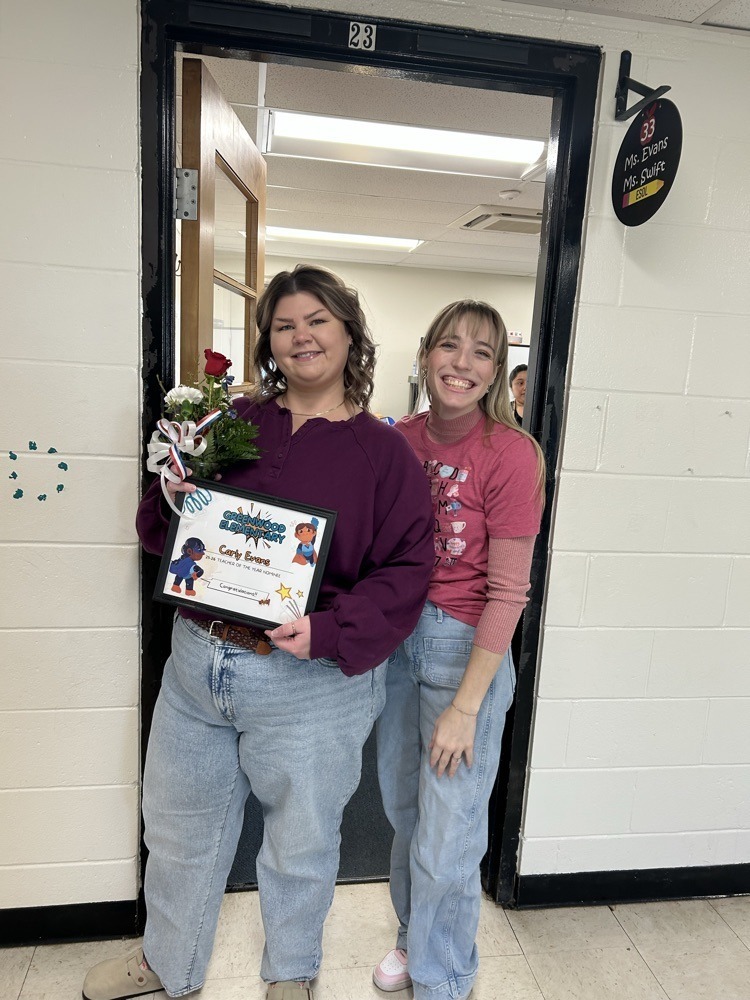two teachers smiling for a photo while standing in a doorway
