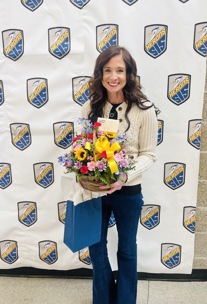 teacher smiling and holding flowers