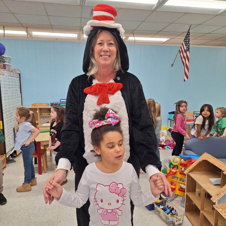 Teacher reading to students dressed as cat in the hat