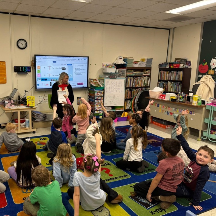 Teacher reading to students dressed as cat in the hat