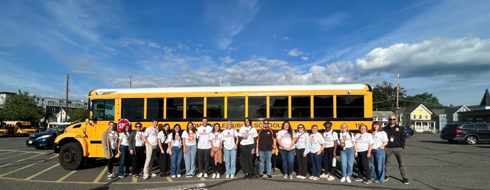 adults standing in front of a bus