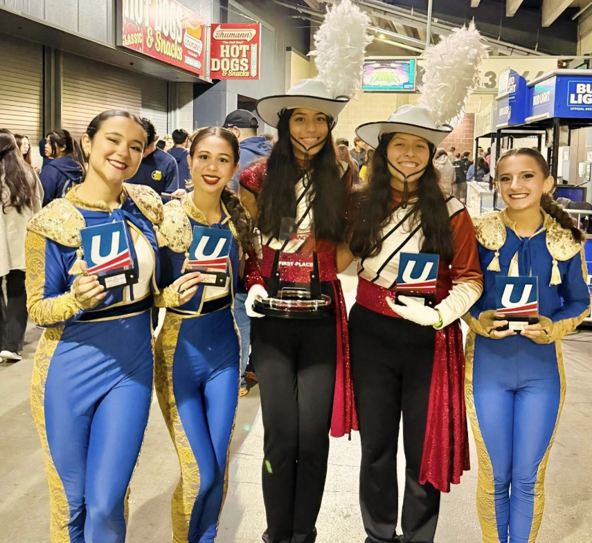 marching band members holding trophies