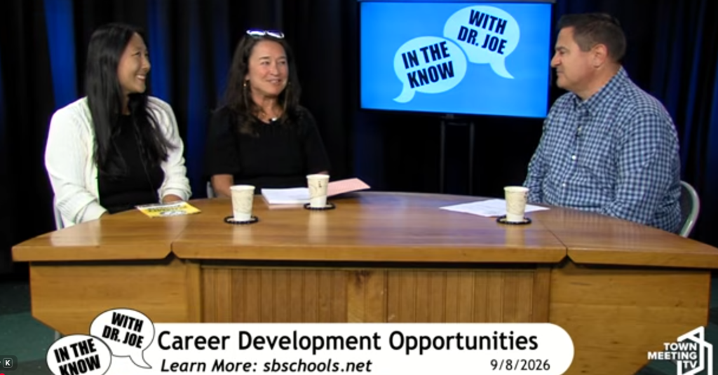 Three people sit around a desk, facing a screen. The text "Career Development Opportunities" appears below.