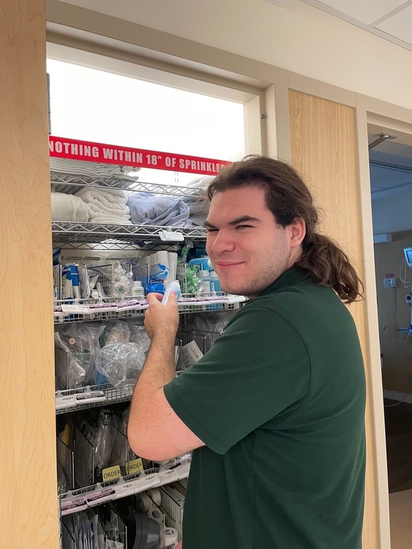 Project SEARCH worker stocking inventory on company shelves