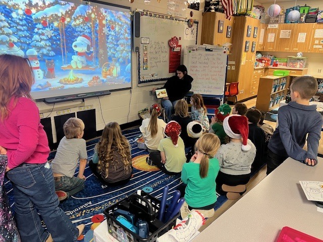 English IV students present children’s books they created to EC students.