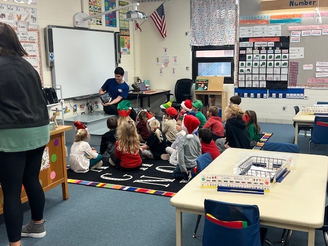 English IV students present children’s books they created to EC students.