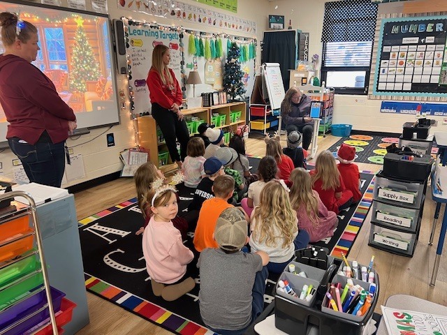 English IV students present children’s books they created to EC students.