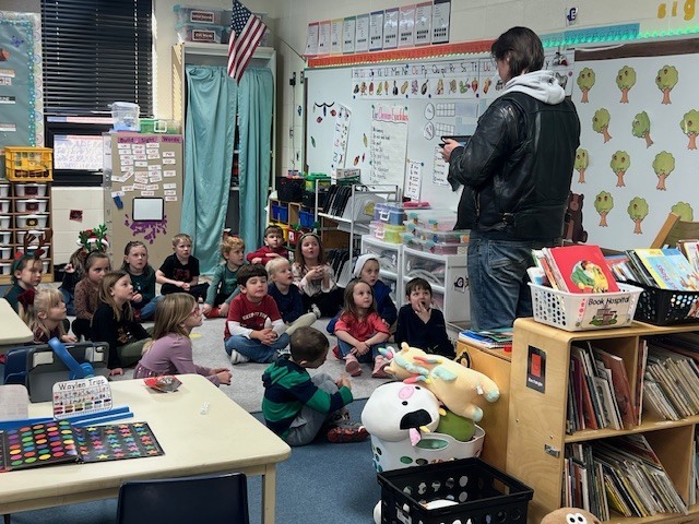 English IV students present children’s books they created to EC students.