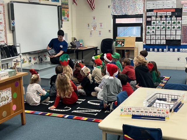 English IV students present children’s books they created to EC students.