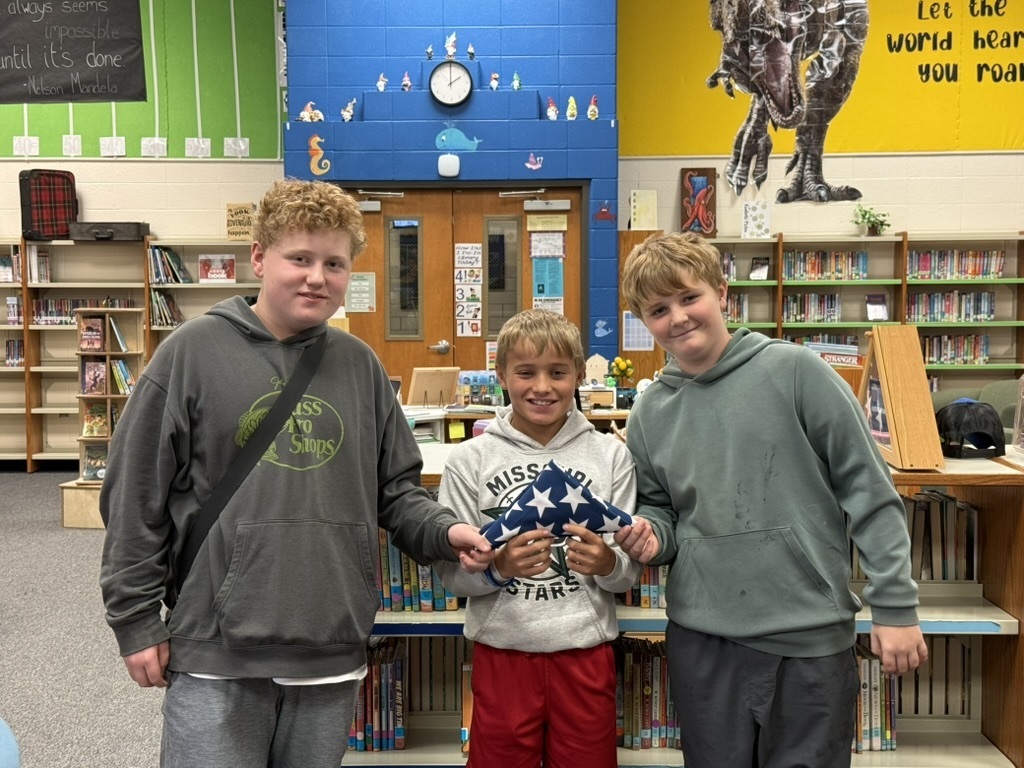 Students holding US Flag after folded.