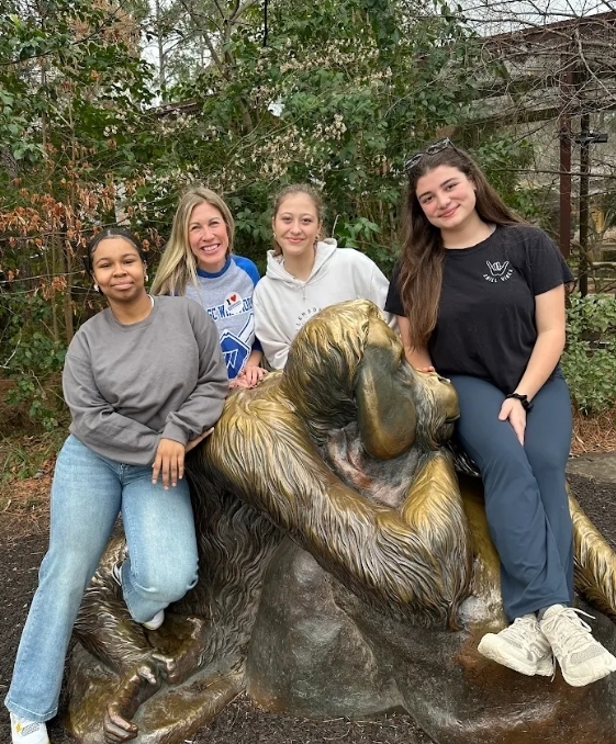 Three girls and their female teacher on a bronze ape statue