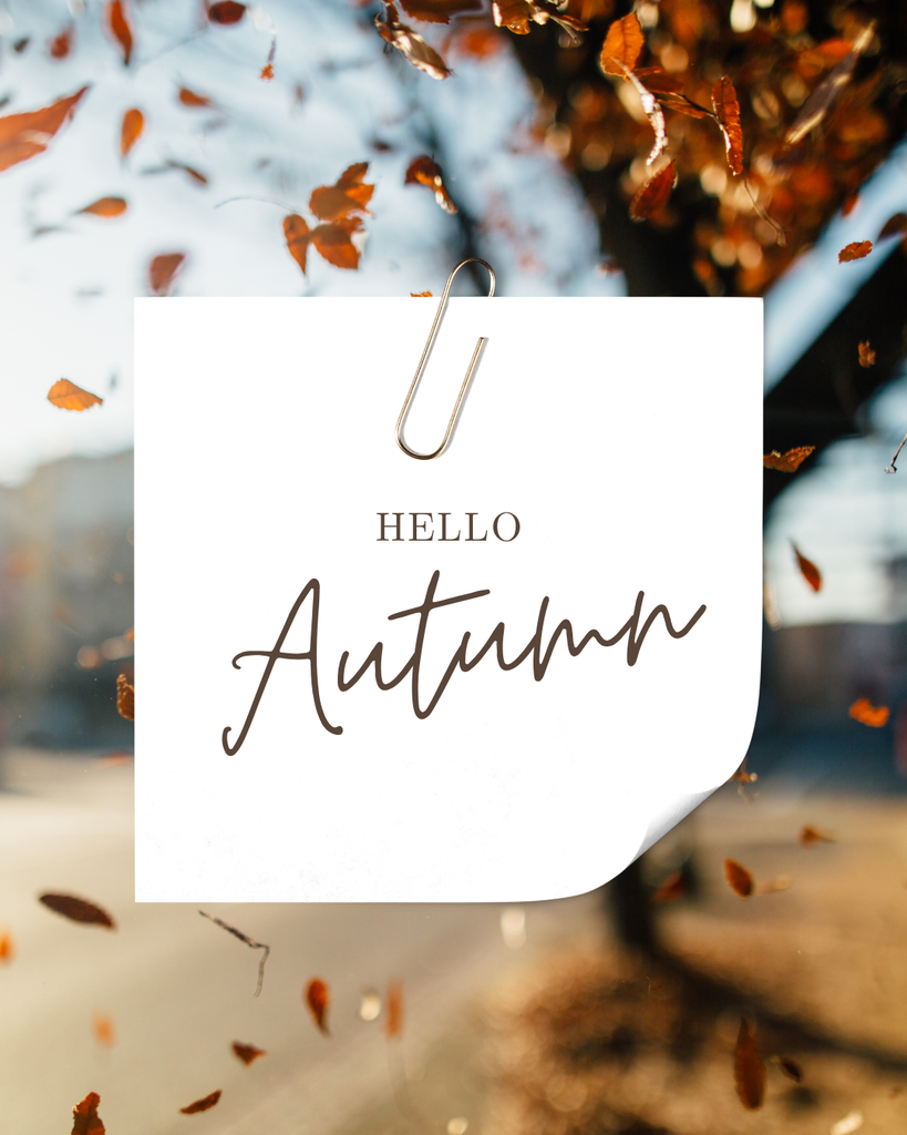 Tree in the background with leaves falling. Post it note with a paperclip with the words Hello Autumn.