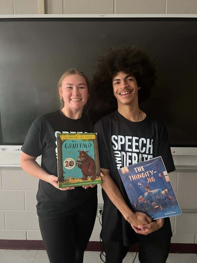 students posing with the books they performed for a class