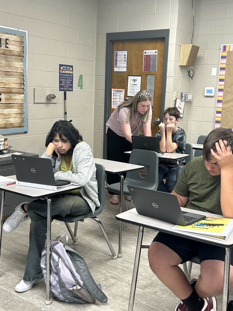 Mrs. Barrett is shown helping her students.
