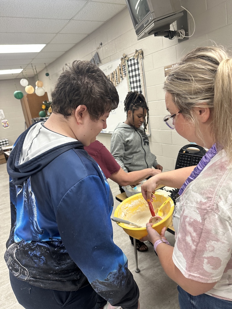 Ms. Butler with student helping.